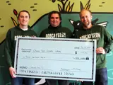 Daniel Longfield from McThirsty's Pint (left) and Richard Wood from Bobcaygeon Brewing Co. (right) present Otonabee Conservation former Board of Directors Chair, Ryan Huntley with a check for $1,750 from Community Brew #2 in support of Jackson Creek Trail revitalization.